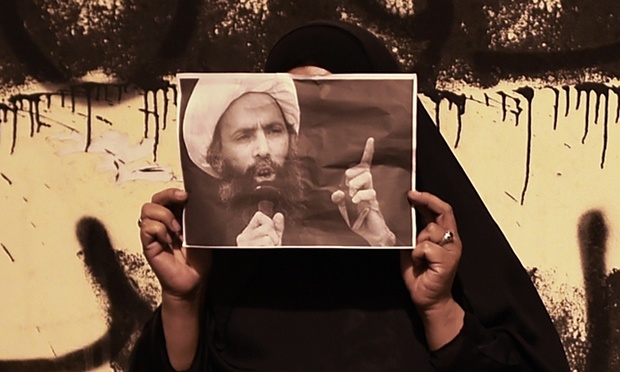 A woman near Manama, Bahrain, holds up a portrait of Shia leader Nimr Baqir al-Nimr in solidarity. Photograph: Mohammed Al-Shaikh/AFP/Getty Images