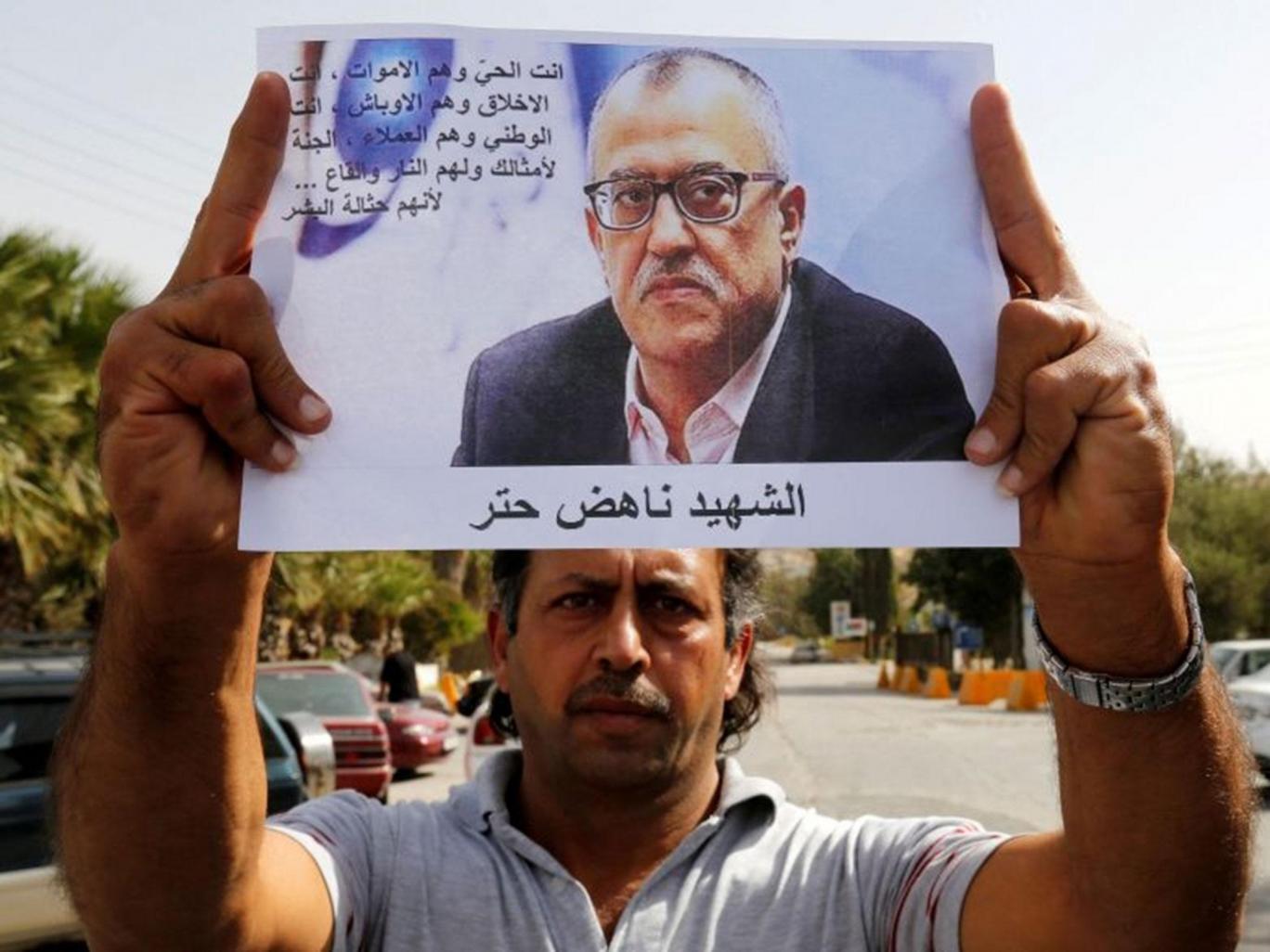 Perfect Assassination of Jordanian Writer - MPC Journal - A relative of Jordanian writer Nahed Hattar holds his picture during a sit-in in the town of Al-Fuheis near Amman, Jordan, 25 September, 2016 Reuters