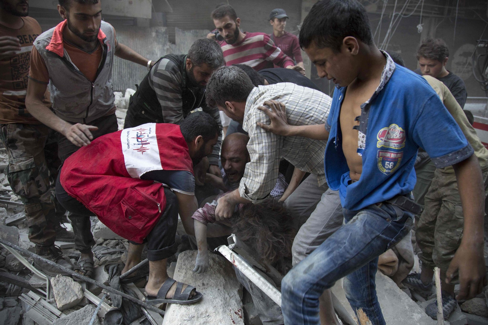 A man crying over the body of his child after she was pulled from the rubble of a building following government airstrikes Tuesday on a rebel-held neighborhood in Aleppo. Credit Karam Al-Masri/Agence France-Presse — Getty Images