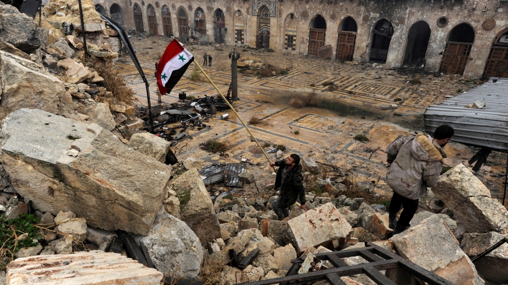 Syrian soldier with the national flag inside Aleppo's Umayyad Mosque [Reuters/Omar Sanadiki]