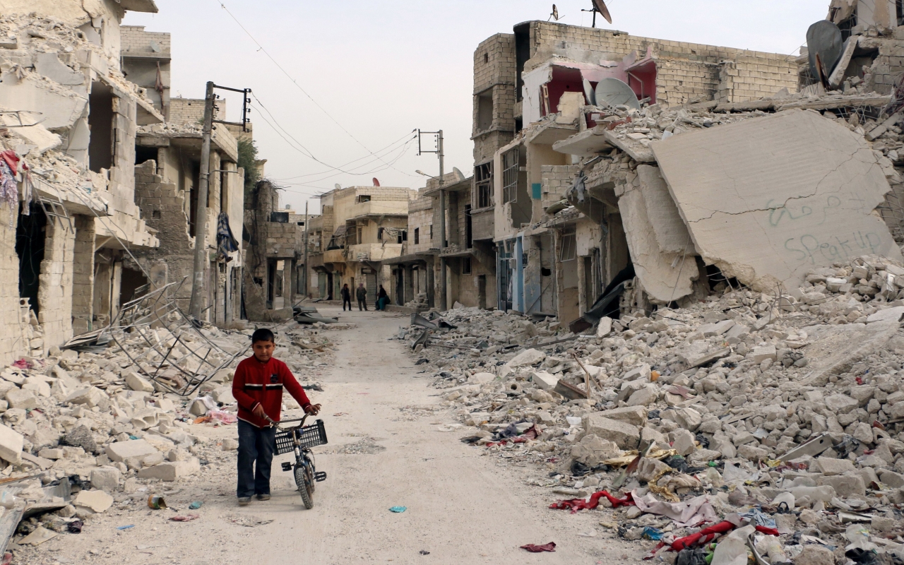 Syria Safe-Zones-Plan Takes Effect - A Syrian boy walks with his bicycle in the devastated Sukari district in the northern city of Aleppo – © Photo: Baraa Al-Halabi/AFP