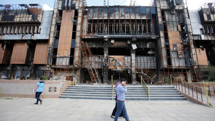 Iraqi students walk near a building of the central Library of the University of Mosul