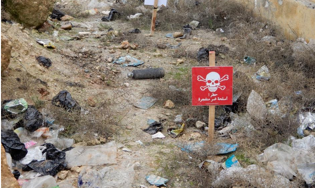  Expand An unexploded 9N24 fragmentation submunition is marked by deminers in Sarmin, Idlib governorate. © 2020 Syria Civil Defense 