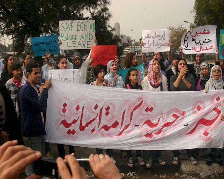 A group of young ladies carrying a large banner saying "bread - freedom - human dignity"[lit. khobz - huriyya - karama insaniyya] in Tahrir Square on 01 February 2011. © Image: Osama M. Hijji.